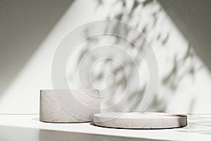 Luxury marble table with plant shadow on white wall and stone podium for product placement display. Trendy neutral aesthetic