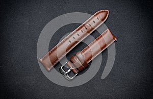Luxury, minimalist brown tanned leather watch strap on a black surface background