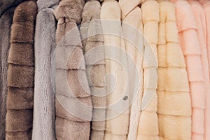 Luxury mink coats. Grey, brown, pearl color fur coats on showcase of market. Best gift for women is mink coat. Outerwear