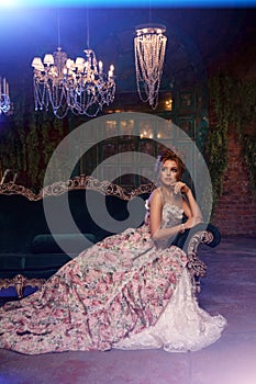 Luxury model in vintage style. Beautiful woman with a stunning hairstyle and make-up in a rococo dress. Girl at the Masquerade