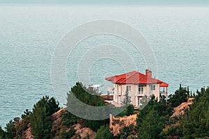 Luxury modern house with red roof on sea shore. Vacation home for family. New residential building. Sale or rental of apartments