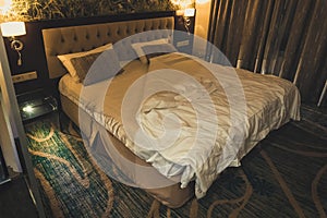 luxury modern style bedroom. Large double bed in a small bedroom in the room evening. light from night lights.
