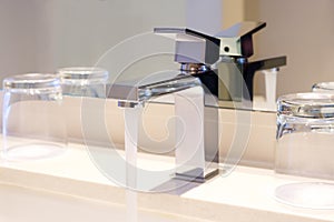 Luxury modern style faucet on a white sink in a beautiful bathroom