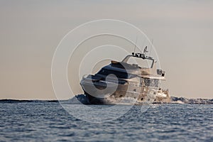 luxury motor yacht sailing at sunset.