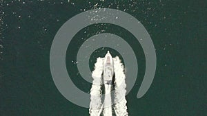 Luxury motorboat yacht traveling through ocean, aerial birds eye view follow