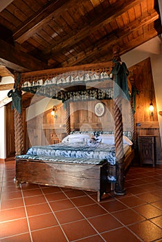 Luxury mountain hotel interior design. Sleeping room wooden canopy bed