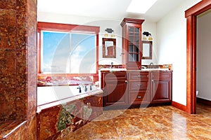 Luxury new home bathroom with red marble and mahogany wood.