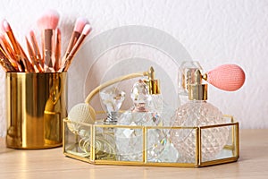 Luxury perfumes and makeup brushes on dressing table