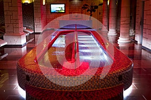 Luxury plunge pool in the centre of the column design spa. A filled spa pool in a pillared hall of dainty sauna. Indoor aquazone