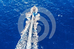 Luxury private speed motor boat leaving blue sea. Aerial top view