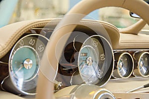 Luxury Race Retro Car Interior With Beige Finish. Speedometer And Tachometer On Dashboard. Car In Workshop