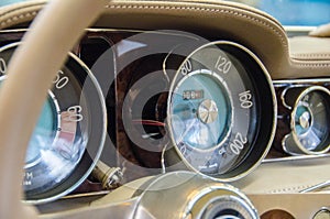 Luxury Race Retro Car Interior With Beige Finish. Speedometer And Tachometer On Dashboard. Car In Workshop