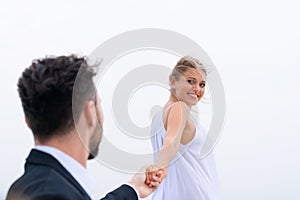 Luxury relaxing couple in nice dress and suite hold hand background white sky. Concept business travel