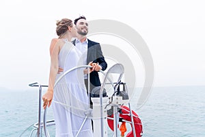 Luxury relaxing couple traveler in nice dress and suite stand with driver hand steering wheel on boat yacht. Concept business