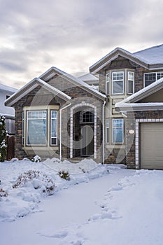 Luxury residential house in snow on winter cloudy day