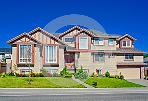 Luxury residential house with wide garage door on blue sky background