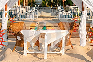 Luxury resort hotel outdoor restaurant on the beach, tropical island cafe, table ready for serving. Summer vacation or holiday