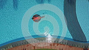 Luxury resort hotel pool and woman swims on ring