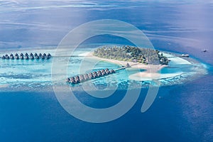 Luxury resort island in Maldives with water bungalow background and blue sea sky aerial view