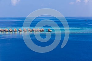 Luxury resort island in Maldives with water bungalow background and blue sea sky aerial view