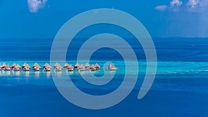 Luxury resort island in Maldives with water bungalow background and blue sea sky aerial view