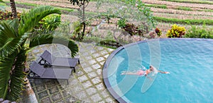 Luxury Resort. Man Relaxing In Infinity Swimming Pool Water. Beautiful Happy Healthy Male Model Enjoying Summer Travel