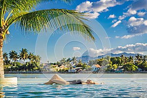 Luxury resort swimming pool. Beautiful woman tourist relaxing in holiday retreat on summer travel vacation. Bikini girl