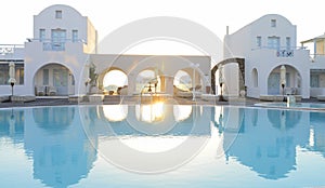 Luxury resort white villas reflecting in blue pool water