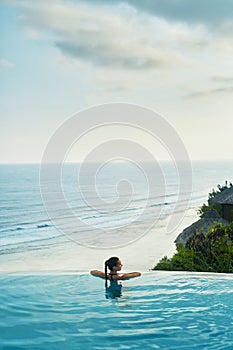 Luxury Resort. Woman Relaxing In Pool. Summer Travel Vacation