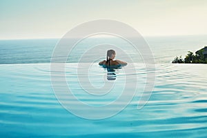 Luxury Resort. Woman Relaxing In Pool. Summer Travel Vacation