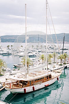 Luxury sailing yacht moored at the pier against the background of motor yachts