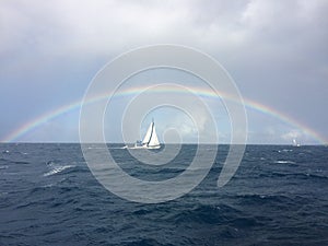 Luxury sailing yacht under a rainbow on the open sea