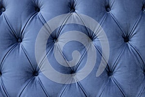 luxury seamless background of velvet blue fabric on upholstered furniture close-up