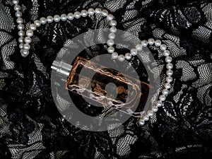 Beautiful set of women`s evening accessories. Pearl necklace, perfume and lace black dress. Elegant classic female jewel