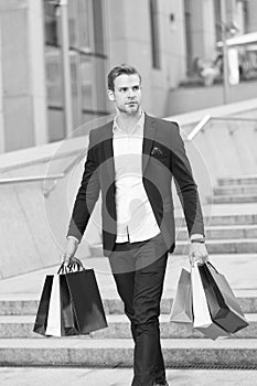 Luxury shopping. Boutique gallery client. Man shopper carries shopping bags urban background. Successful businessman
