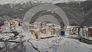 luxury ski resort in mountains, aerial view on high buildings of hotels and sky tram supports, sport activities