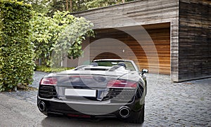 Luxury sports car in front of a garage