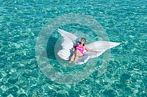 Luxury summer vacation beach woman relaxing lying down on inflatable pool float floating at Maldives sun tanning. Model sleeping o