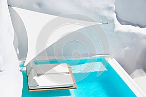 Luxury swimming pool with blue water and white chaise lounges