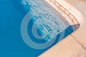 Luxury swimming pool edge, Mediterranean pool in sunlight. Recreational and relaxing background