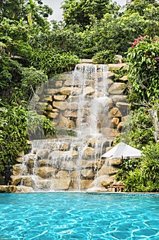 Luxury swimming pool nearby tropical forest and waterfall