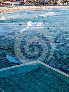 A luxury Swimming pool next to blue Ocean on Sunny day