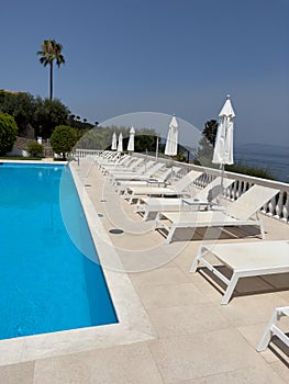 The luxury swimming pool with white sun loungers sunshades