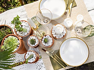 Luxury table setting with candles, succulents and tropical plants decoration.