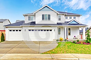 Luxury two level house exterior with garage and concrete driveway.