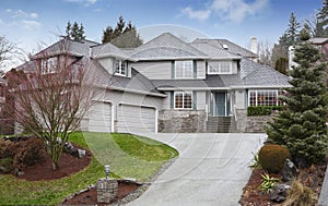 Luxury two level house with garage and driveway.