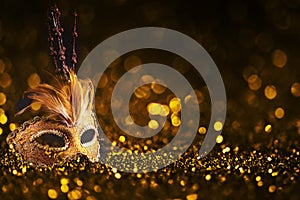 Luxury venetian mask on dark godlen bokeh background. New year and christmas party celebration design banner