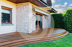 Luxury villa exterior with garden terrace and wooden floor. photo