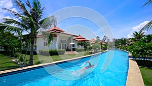 Luxury Villa with Swimmer Swimming in Private Pool.