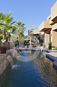 Luxury Villa with waterfall feature and palm trees photo